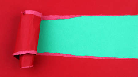 Hole ripped in red paper on green. Christmas background. Copy spaceの写真素材