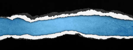 Ripped black paper on blue background, space for copyの写真素材