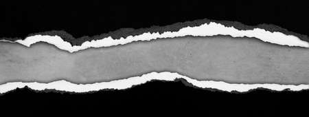 Ripped black paper on grey background, space for copyの写真素材