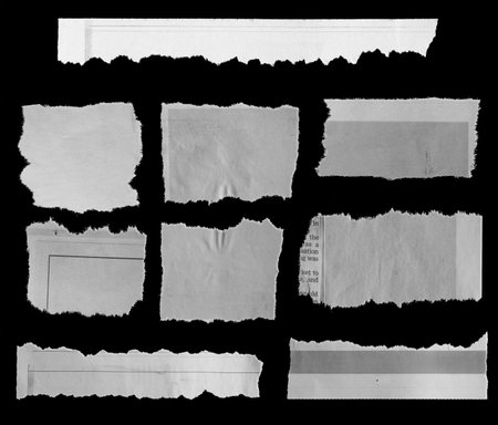 Nine pieces of torn newspaper on black backgroundの写真素材