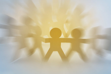 Paper chain team holding hands with focus on leaderの写真素材