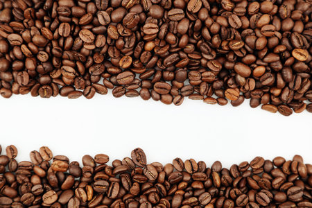 Closeup of roasted brown coffee beans on plain background. Copy spaceの写真素材