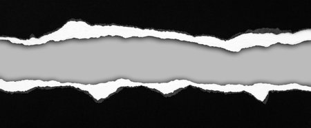 Ripped black paper on grey background, space for copyの写真素材