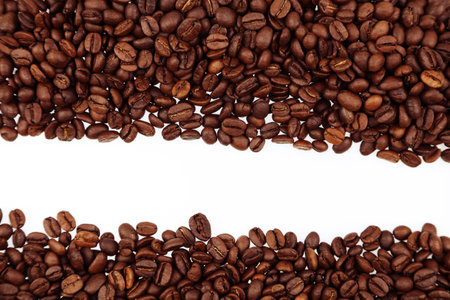 Closeup of roasted brown coffee beans on plain background. Copy spaceの写真素材