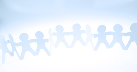 Team of paper chain people united together holding handsの写真素材