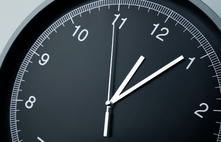 Close-up of hands on clock faceの写真素材