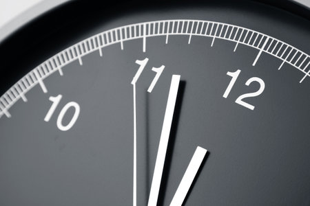 Close-up of hands on clock faceの写真素材