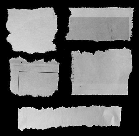 Five pieces of torn newspaper on black backgroundの写真素材