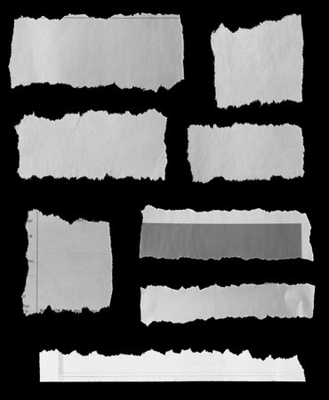 Eight pieces of torn newspaper on black backgroundの写真素材