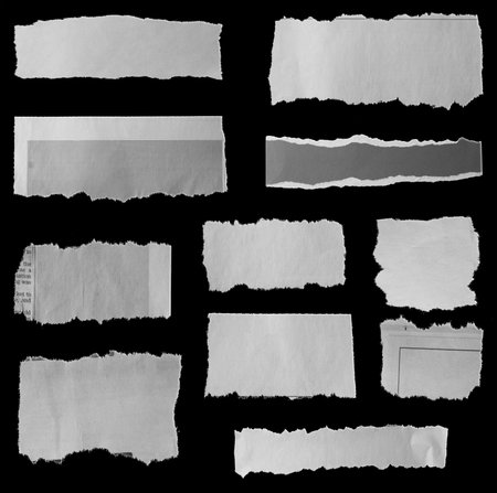 Eleven pieces of torn newspaper on black backgroundの写真素材