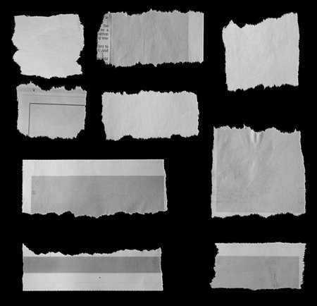 Nine pieces of torn newspaper on black backgroundの写真素材