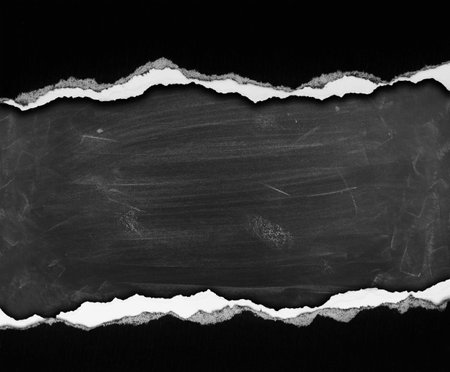 Ripped black paper on blackboard backgroundの写真素材