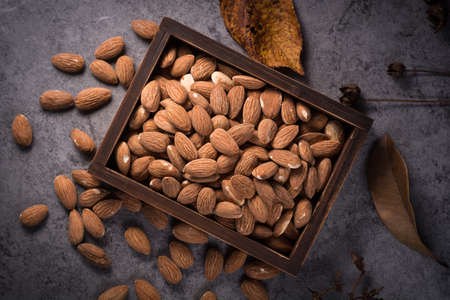 Almonds in brown bowl on wooden backgroundの写真素材