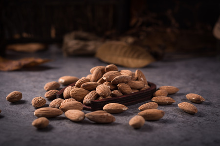 Almonds in brown bowl on wooden backgroundの写真素材