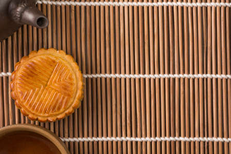 Mooncake and tea,food and drink for Chinese mid autumn festival. Traditional mooncakes on table setting with teapot.の写真素材