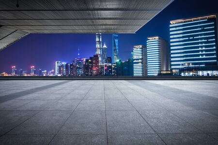 Empty floor with modern skyline and buildings at night in Shanghaiの写真素材