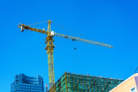 Construction site with cranes on sky backgroundの写真素材