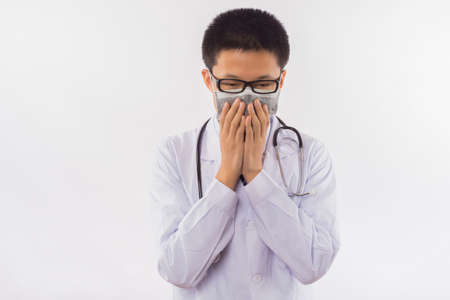 Close-up portrait of a sick doctor, sneezing, isolated on white backgroundの写真素材