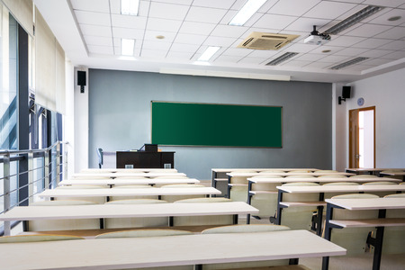 Empty classroom with chairs, desks and chalkboard.のeditorial素材