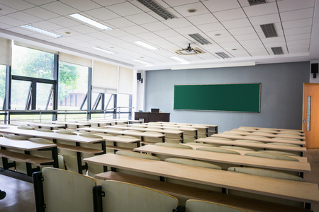 Empty classroom with chairs, desks and chalkboard.のeditorial素材