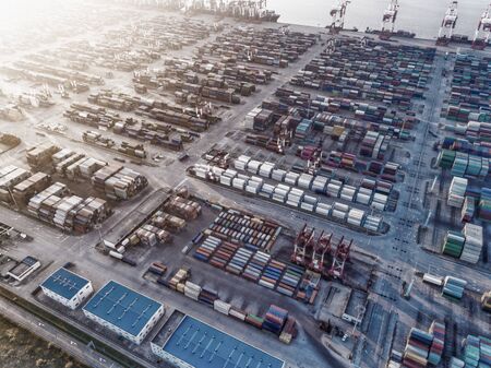 Container ship in export and import business and logistics. Shipping cargo to harbor by crane. Water transport International. Aerial viewの写真素材