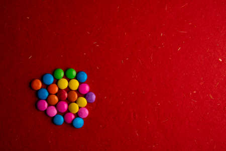Colorful toffee on red backgroundの写真素材