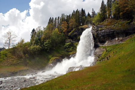 Steinsdalsfossen waterfall in the river of steine ??- scenic landscape with cascade surounded by mountains, Norwayの写真素材