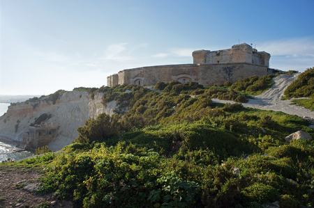 Fortified building on cliffs over harborの写真素材