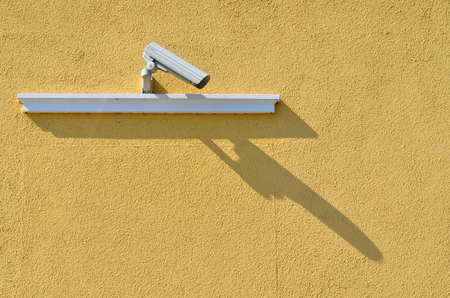 Security camera mounted on a yellow wall