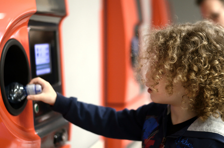 Child puts flats in a vending machineの写真素材