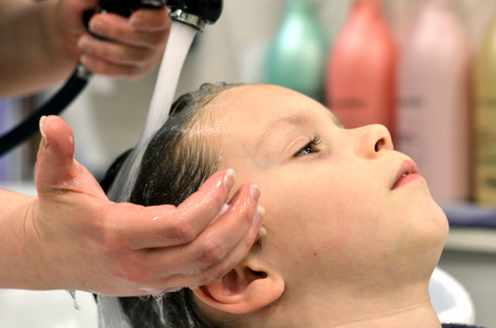 Small child sitting at the hairdresser'sの写真素材