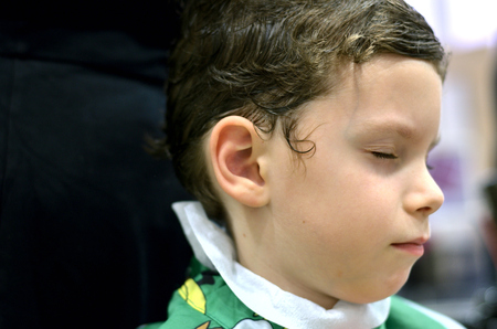 Small child sitting at the hairdresser'sの写真素材