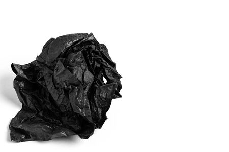 Crumpled sheet of black paper on a white background. close-up. Copy space.の写真素材