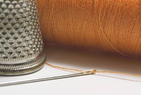 Orange sewing thread needle and thimble の写真素材