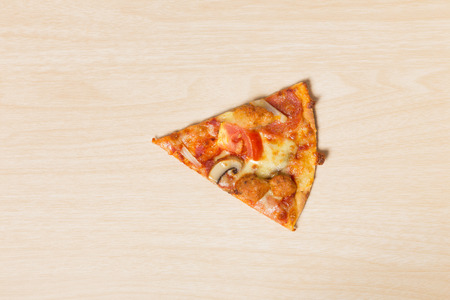 Cut off slice pizza on wood backgroundの写真素材