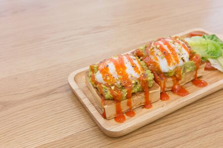 benedict egg on piece of bread with kiwi sauce on the wooden tableの写真素材