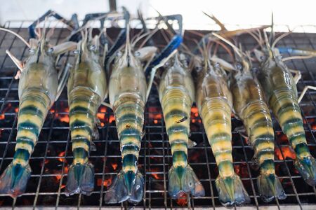 Cooking king prawns grilled on the flaming grill in the restaurantの写真素材