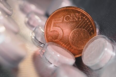 Five euro cent coin on a pack of pills