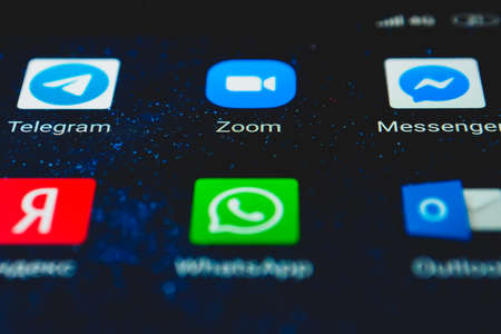 Zoom icon app and other messenger icon app on the screen smartphone closeup. Zoom Video Communications is a company that provides remote conferencing services.のeditorial素材