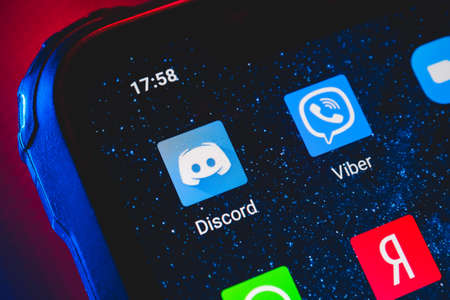 Discord app icon on the screen smartphone. Discord is platform designed for video gaming communities, that specializes in text, image, video and audio communication.のeditorial素材