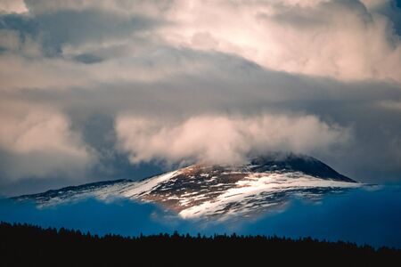 Spectacular view of a mountain range in the clouds in Ulagansky district of the Altai Republic,...