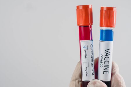 Vacuum tubes with a blood sample with a positive result for Covid-19 infection and sample of vaccine...