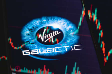 Kazan, Russia - May 31, 2021: Virgin Galactic is company developing commercial spacecraft. Virgin Galactic logo on smartphone screen. Stock chart in the reflection.のeditorial素材