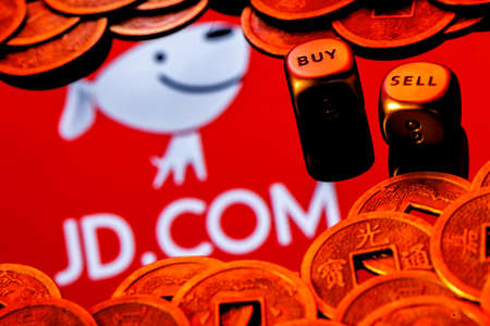 Kazan, Russia - August 20, 2021: JD.com is a chinese e-commerce company. Dices with the words SELL BUY. JD.com logo surrounded by feng shui coins.のeditorial素材