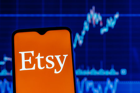 Kazan, Russia - Oct 6, 2021: Etsy is an American e-commerce company focused on handmade items and craft supplies. Smartphone with Etsy logo on the background of the stock chart.のeditorial素材