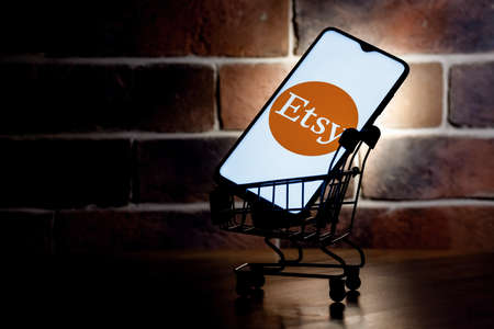 Kazan, Russia - Oct 6, 2021: Etsy is an American e-commerce company focused on handmade items and craft supplies. Smartphone with Etsy logo on screen in the shopping cart.のeditorial素材