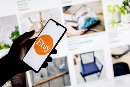Kazan, Russia - Oct 6, 2021: Etsy is an American e-commerce company focused on handmade items and craft supplies. A smartphone with the Etsy logo in a hand.のeditorial素材