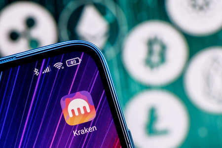 Kazan, Russia - Oct 12, 2021: Kraken is a cryptocurrency exchange. Kraken app on smartphone screen against the background of the main cryptocurrencies.のeditorial素材