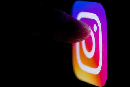 Kazan, Russia - Oct 21, 2021: The finger reaches for the Instagram social network on the smartphone...
