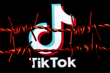 Kazan, Russia - Oct 31, 2021: TikTok social network logo behind barbed wire. The concept of TikTok censorship and prohibition.のeditorial素材